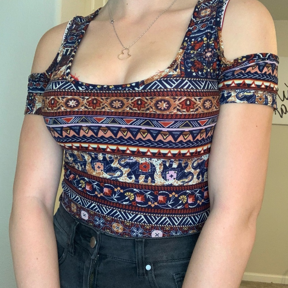 A brown shirt with tribal prints and elephants.